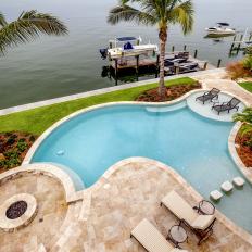 Bay Front Home Backyard Swimming Pool With Marble Tile Patio and Circular Fire Pit 