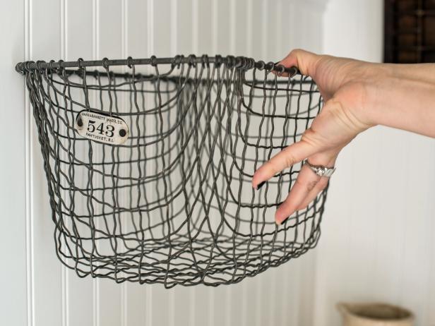 Hook basket onto both nails to hang. If basket may be knocked off easily, secure it to nails with lightweight wire. Tip: If basket will be filled with more than just paper rolls or hand towels, make sure nails are inserted into studs or use screws and drywall anchors.