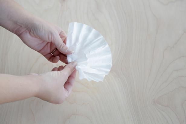 Fold a single coffee filter in half. Fold right side in toward center and repeat on left side until a cone shape is achieved. Repeat process on five additional coffee filters. Set aside.