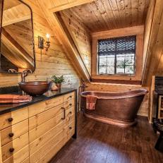 Copper Bathtub In Rustic Wood Loft Bathroom With Dark Hardwood Floor and Black Granite Countertop 