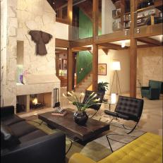 Modern Double Height Living Room Wood Beam Structure, Textured Chimney Wall and Tufted Leather Seating 