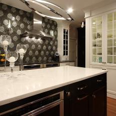 Floral Tile Backsplash and Stainless Steel Fixtures in Contemporary Kitchen With Black and White Island 