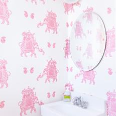 Pink Elephant Patterned Wallpaper Behind Small Bathroom Floating Sink and Matching Sconce