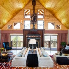 Rustic, Wood Living Room With Mirrored Sitting Set Ups, Wrought Iron Chandelier and Large Fireplace Surround