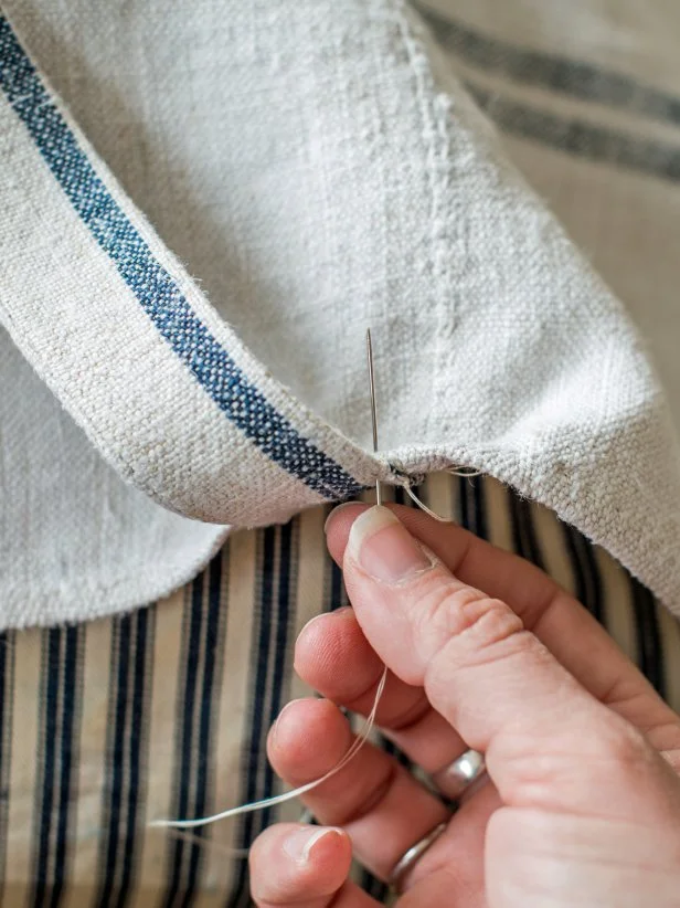 Hand-stitch ties (or ribbons) onto desired locations on top and bottom side of dog bed, so both sets of ties are symmetrical and line up when tied.