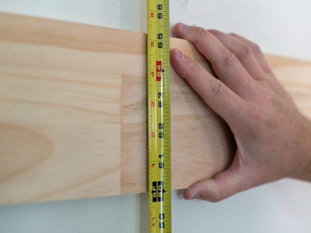 Measure 60” up from the floor with a measuring tape and mark with pencil.  This is the height of the bottom of the horizontal top rail.