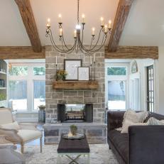 Open Concept Living Room With Exposed Beam Vaulted Ceilings and Gray Stone Fireplace