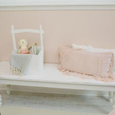 Girl's Bedroom White Bench With Ruffled Pillows and Small Toy Basket 