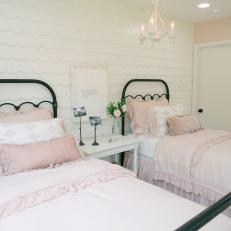 Pink and White Girl's Bedroom With Wood Shingle Accent Wall and Ruffled Bed Linens  