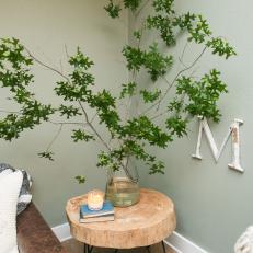 Living Room Detail Featuring Natural Wood Round End Table and Distressed Wall Decor 