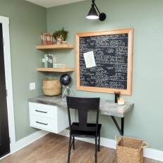 Office Nook Featuring Concrete Tabletop, Wallpaper Covered Cork Board and Floating Shelves 