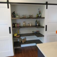 White Barn Door Pantry With Natural Wood Horseshoe Floating Shelves  