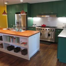 Warm Tone Country Kitchen With Dark Green Cabinetry and Long Island With Wood Countertop 