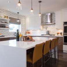 Bright Midcentury Modern Kitchen With Full Wall Backsplash, Mustard Yellow Bar Chairs and Large White Island