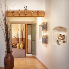 Southwestern Foyer Featuring Over-Door Mounted Doll Display, In-Wall Shelving and Neutral Floor Tile 