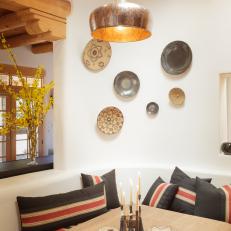 Charcoal and Red Striped Pillows on Built in Bench in Southwestern Dining Room With Plate Wall and Centerpiece Decor
