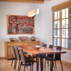 Natural Wood Exposed Beams Over Contemporary Wood Dining Table, Leather Dining Chairs and Southwestern Decor 