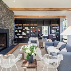 Textured Rock Fireplace Surround and Built in Black Bookshelf in Contemporary Living Room With Blue Sofa 