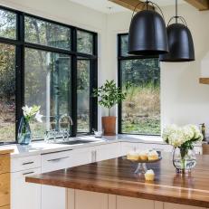 Contemporary Kitchen With Natural Wood Furniture Details, Large Black Bucket Pendant Lights and Natural Light 