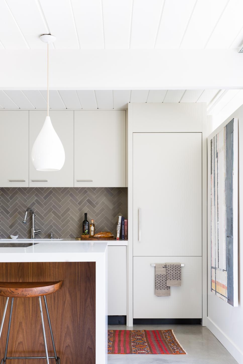 Herringbone Heath Tile Gray Backsplash in White Kitchen With Walnut