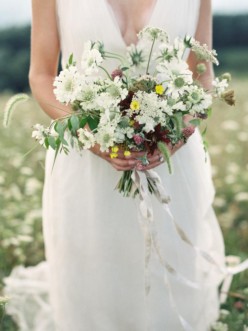 Woman in White Dress Holding Wildflower Bouquet