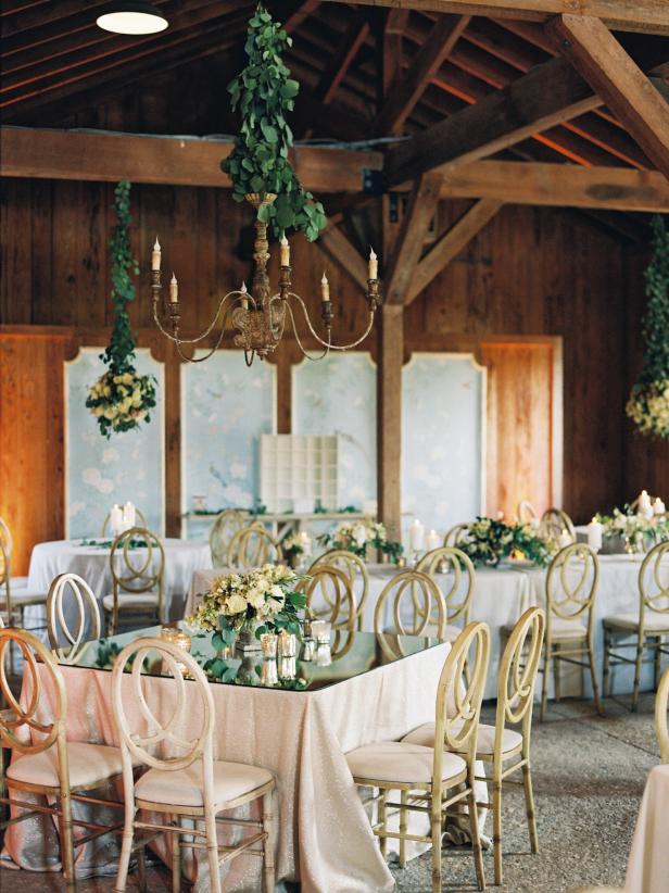 Barn Interior Decorated With Wedding Greenery and Tables