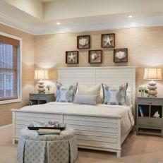 Stylish Coastal Bedroom With Textured Wallpaper, Deep Tray Ceiling and Pleated Upholstered Table 