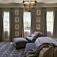Window Trio and Plush Neutral Armchair With Matching Ottoman in Traditional Bedroom  