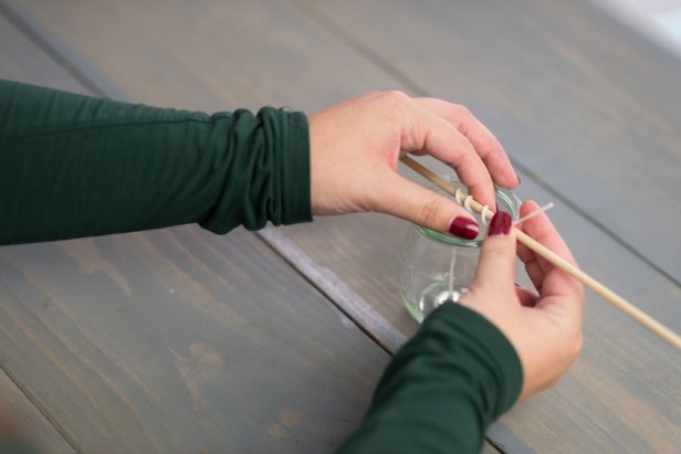 Twist a wooden dowel around the wick to help keep the wick upright when pouring the wax into the jar.