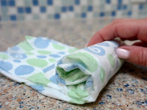 Next, roll up each diaper individually and secure with a small rubber band.