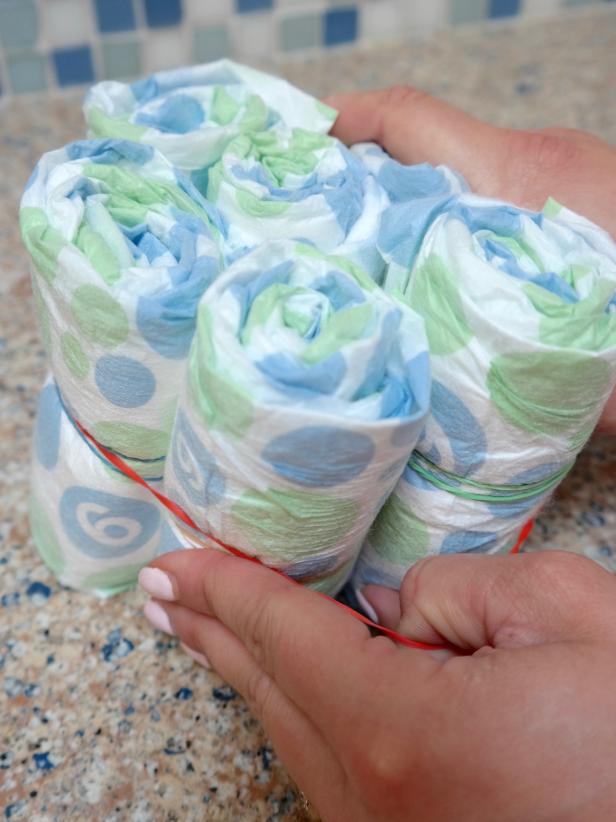 Now, stand up the diaper rolls and secure with large rubber bands to create your two “cake” layers.
