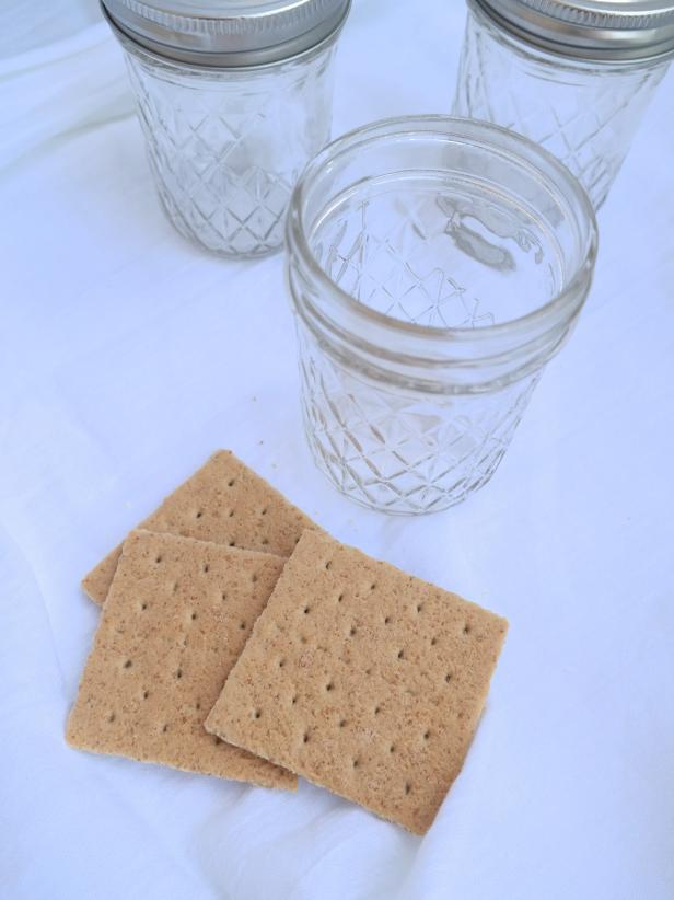 Break up graham crackers by hand or pulse in blender. Add 2 tablespoons to the bottom of each jar.
