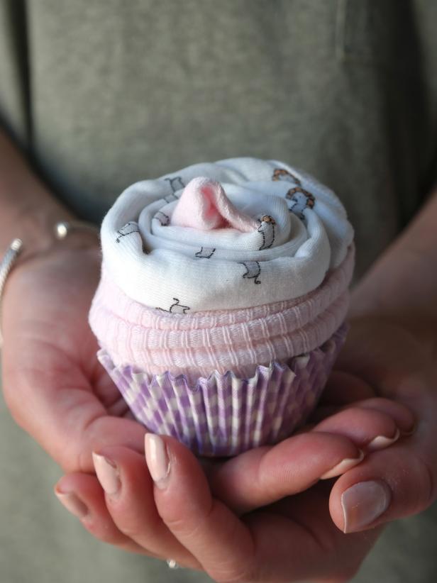 Made with never-have-enough onesies and a pair of baby socks, these little cupcakes are simple to make and a sweet addition to any baby shower. Make a few yourself or print out these instructions to include with the shower invites, asking guests to bring their own onesie creations to present the mom-to-be at the party!