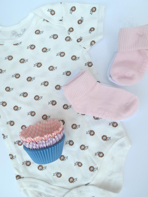 What you’ll need for one cupcake:
• one infant baby onesie
• a pair of baby socks (in a larger size they can grow into)
• cupcake wrappers
• box and ribbon for presentation