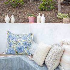 French-Inspired Patio With Floral Pillows and Whitewashed Terra-Cotta Pots