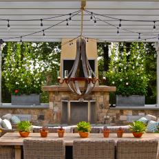 Pergola Covered Dining Patio With Chandelier and String Lights