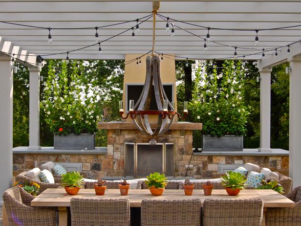 There’s nothing like a chandelier to create an elegant dining atmosphere. But wiring for an outdoor fixture can be complicated, and wet-rated styles are somewhat limited. One solution is to hang a candle chandelier from the beams of a pergola or covered patio, as designer Howard Roberts did here. Use battery-operated LED “candles” for easy operation. Add string lights radiating from the chandelier’s mounting to create a magical canopy of light above diners' heads.