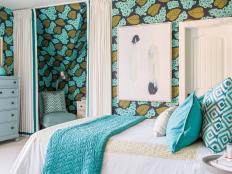 A vibrant navy, teal and green guest bedroom includes modern design details and eye-catching wallpaper.
