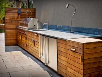 Modern Outdoor Kitchen With Wooden Panels and Brushed Steel 