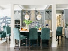 A stunning blue and white tiled backsplash and floor-to-ceiling cabinets combined with a grandiose island for entertaining anchors this family-friendly kitchen.