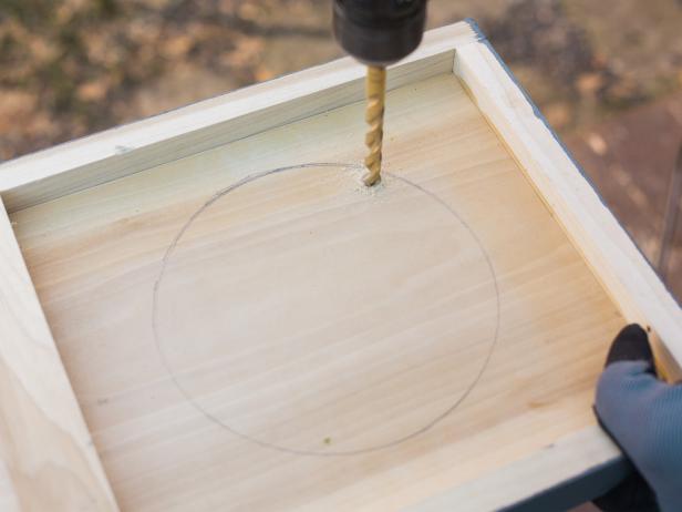 Trace a circle to accommodate your particular ice bucket. To get started with your cut, you’ll need to use a drill with a large bit to make a pilot hole, then insert your jig blade and cut the hole out. Cut the circle out just inside the traced line so that ice bucket fits snug.
