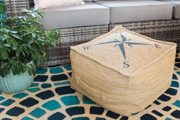 Upgrade a plain jane indoor/outdoor ottoman into something special with a nautically inspired stencil and some navy blue acrylic paint!