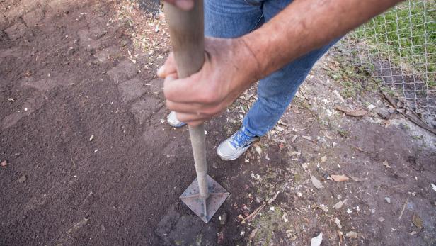 Next, using a shovel, prep the area by digging down at least 6 inches to remove any grass, roots or large rocks. Rake the area out, then tamp down flat with a hand tamper