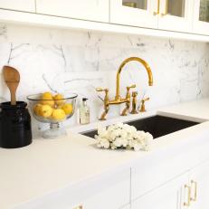 Kitchen Sink With Gold Faucet and White Counters