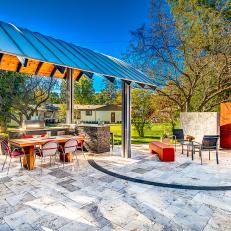 Full View of Outdoor Kitchen Under Curved Pavilion and Modern Outdoor Fireplace