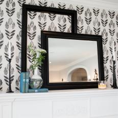 Black and White Patterned Wallpaper Behind Lovely White Mantel With Decorative Display 