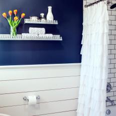 Bright Country Bathroom With Navy Accent Wall, White Subway Tile Shower and Ruffled Shower Curtain