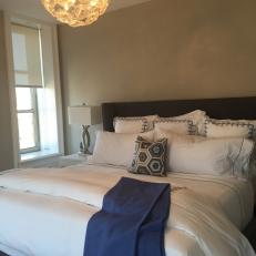 Transitional Bed Design With Dark Bed Frame, Thick White Bed Linens and Blue Accents 