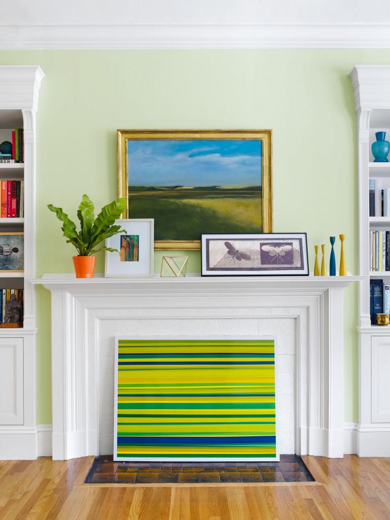 Light Green Living Room With Art Covered Fireplace Mantel
