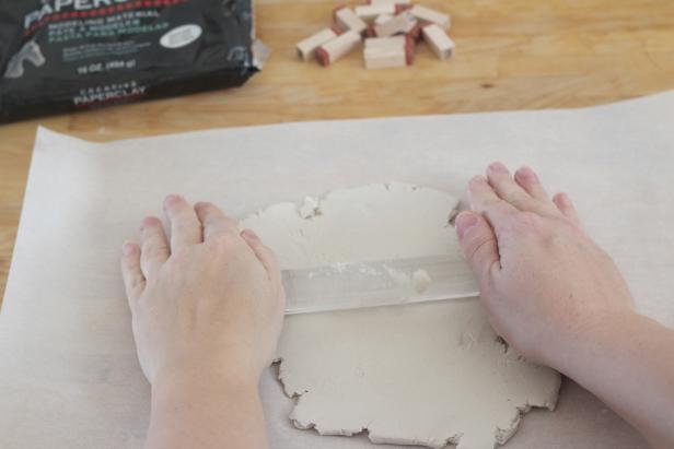Supplies: air dry white craft clay, wax paper, rolling pin, exacto knife, alphabet rubber stamps, straw, ribbon or twine. Step 1: Roll out the white clay on a flat surface covered with wax paper. Clay should be about ¼” thick.
